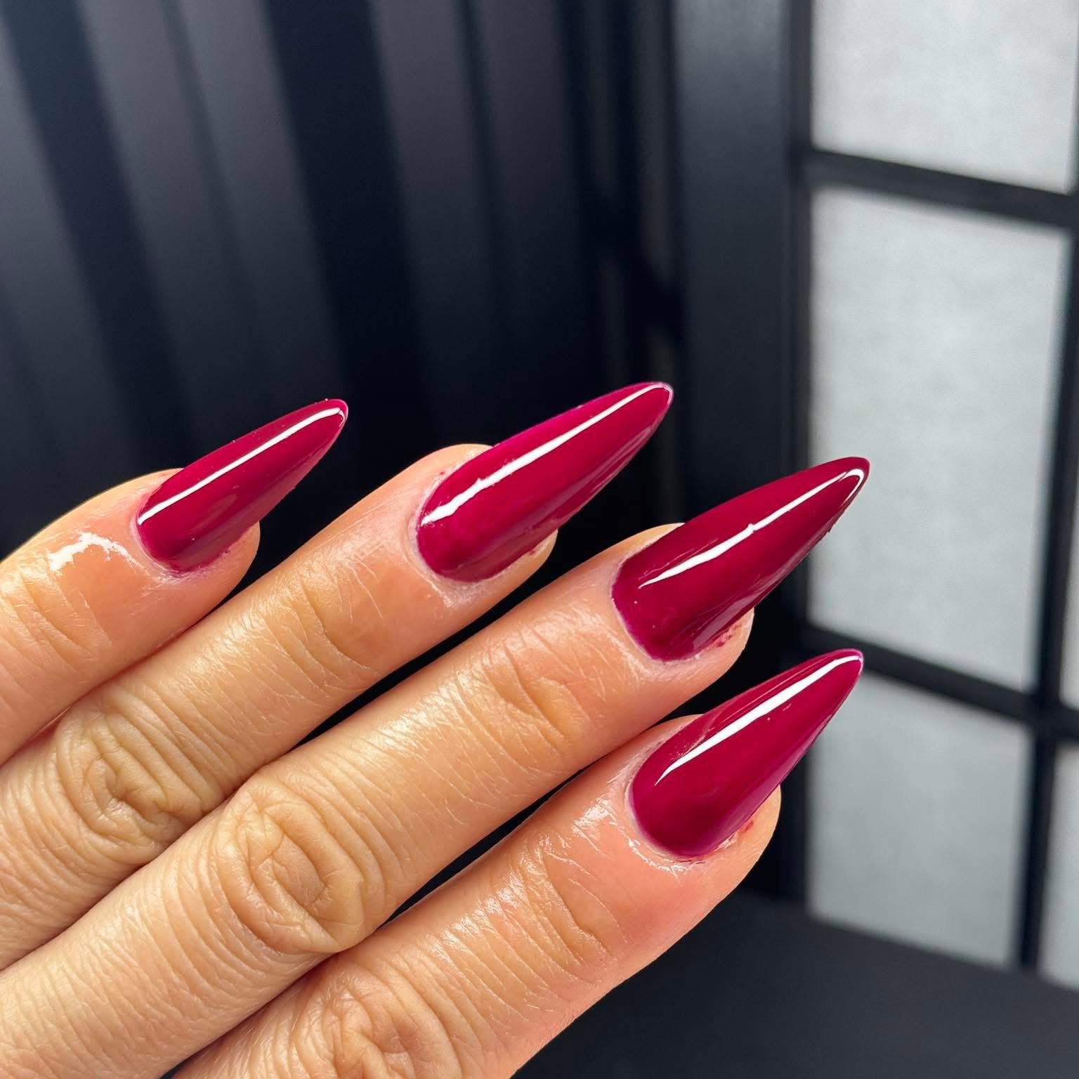 Long magenta stiletto acrylic nail extensions