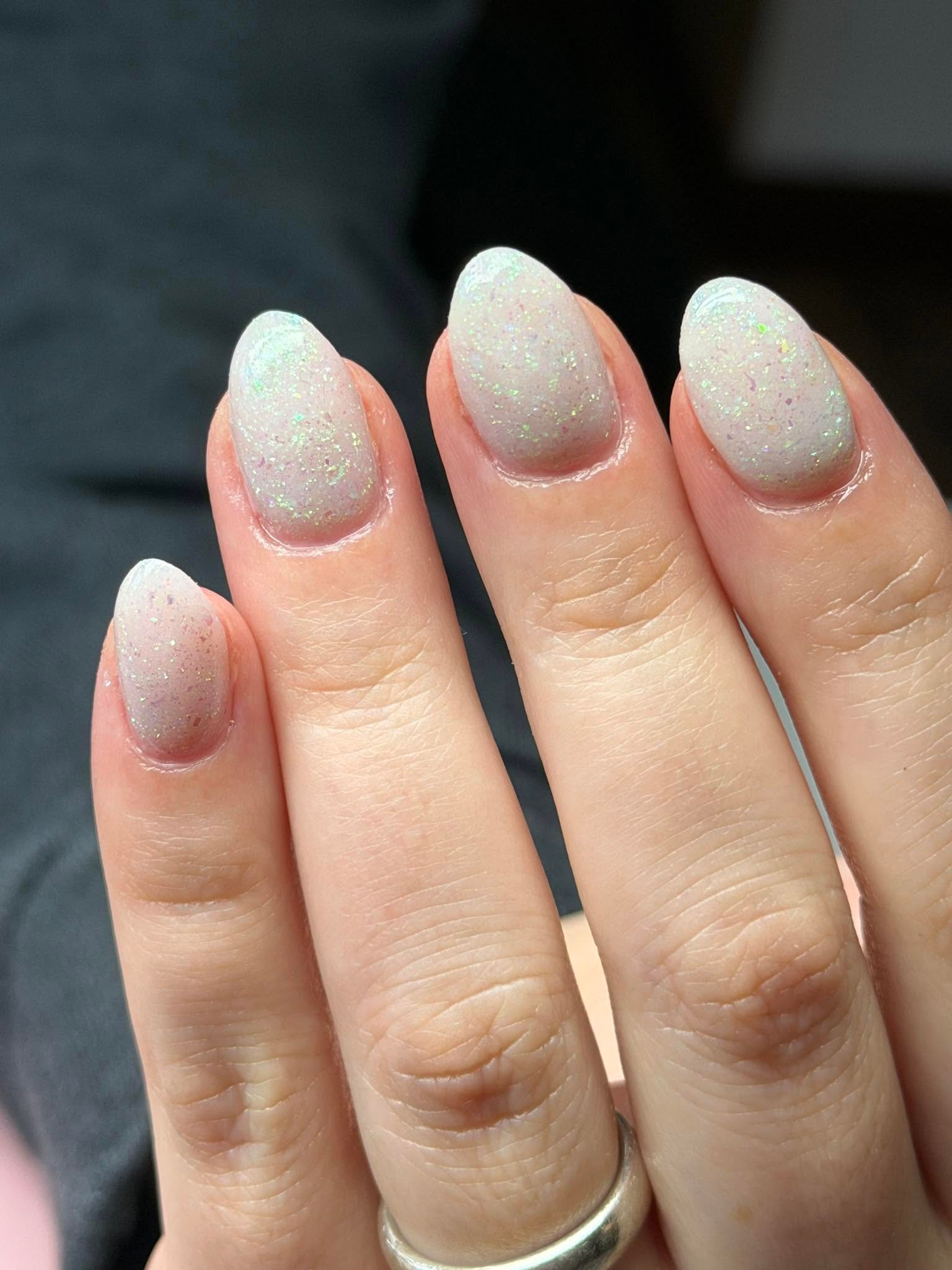 Opal glitter fleck manicure with a soft white base