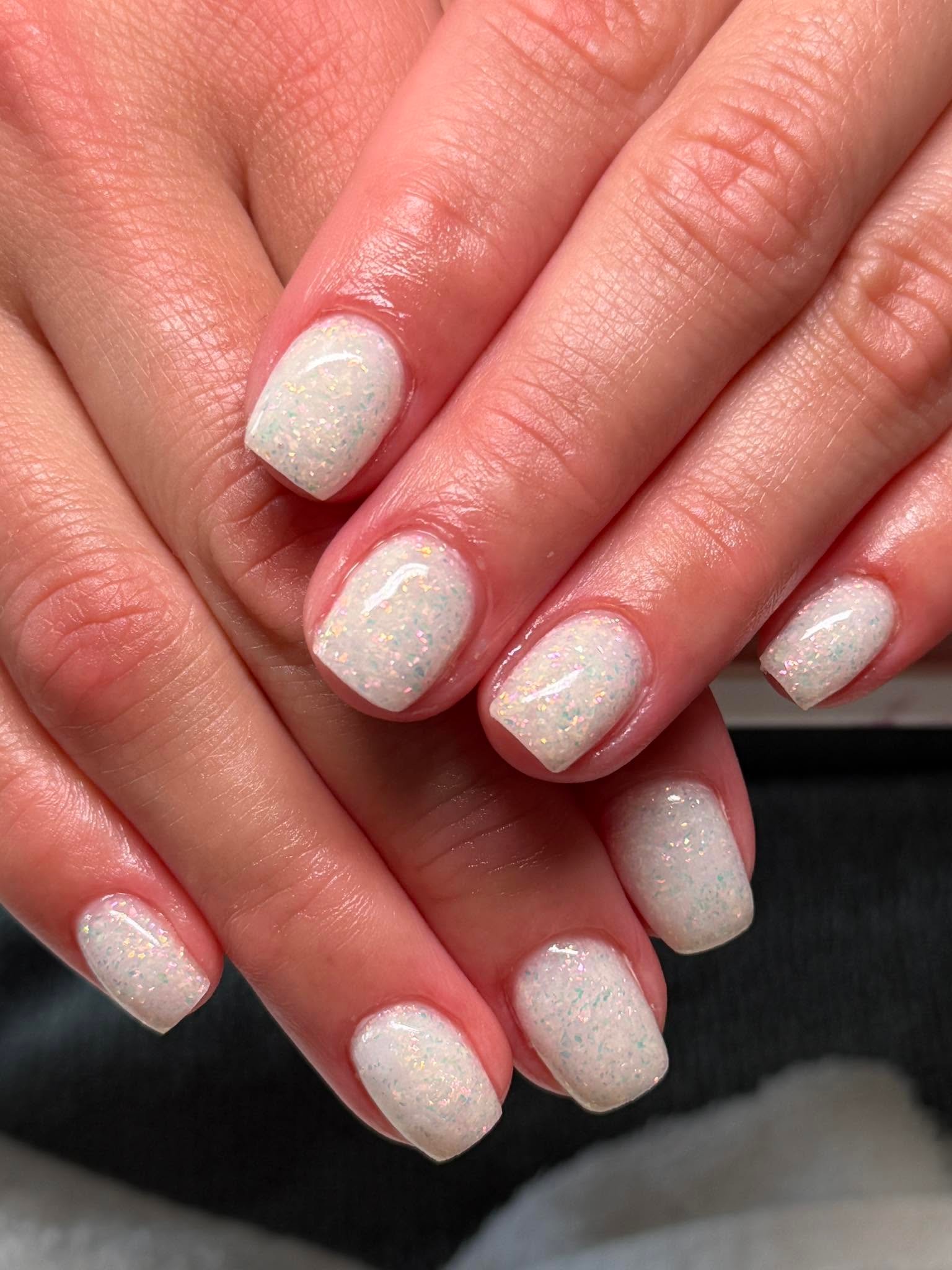 Glitter fleck white manicure with a soft glow