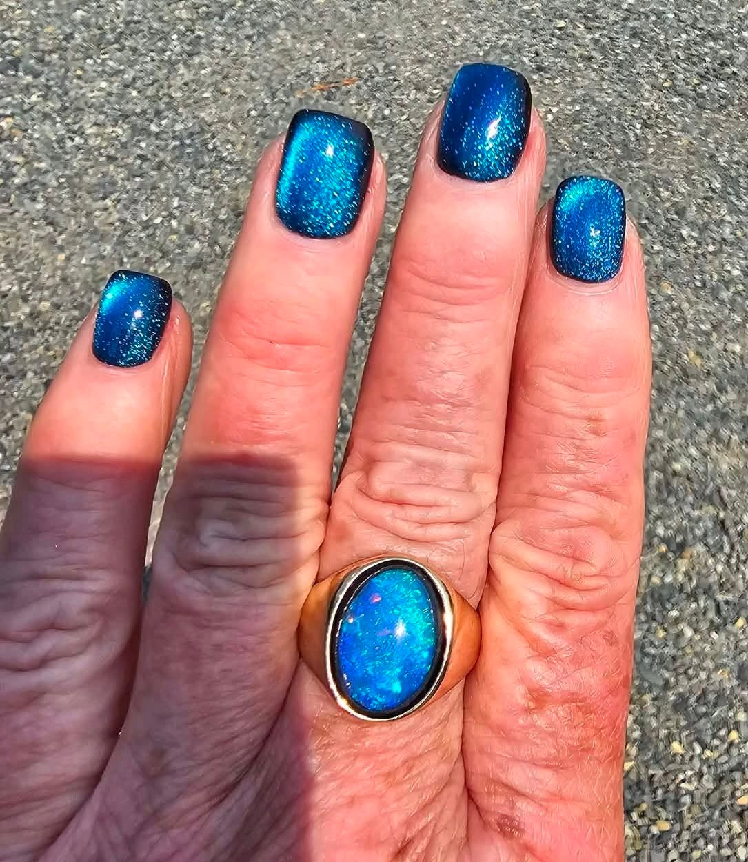 Sparkling ocean blue chrome glitter manicure with opal ring
