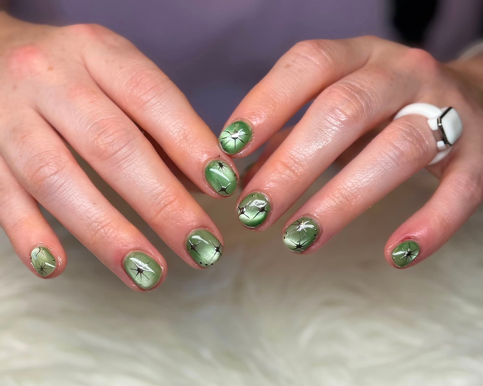 Sage green metallic nails with a star pattern