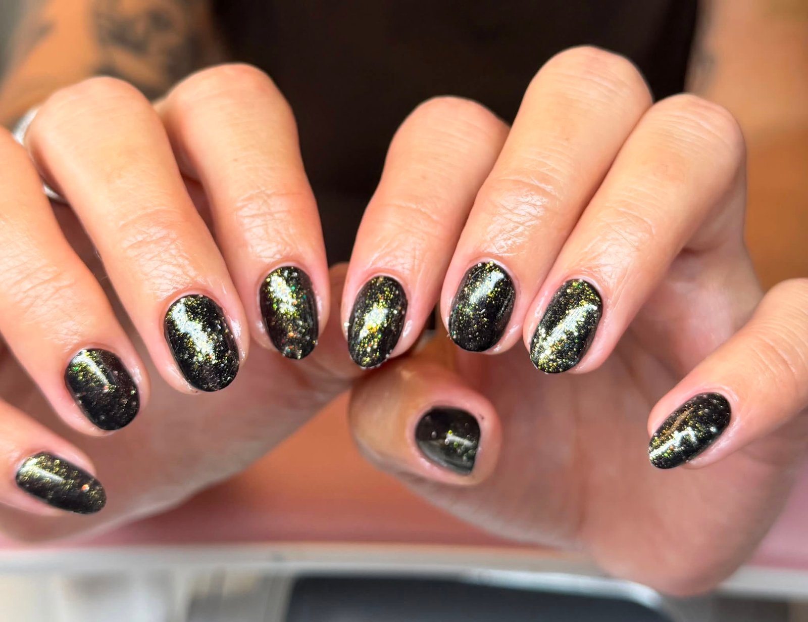 Black manicure with gold glitter dust