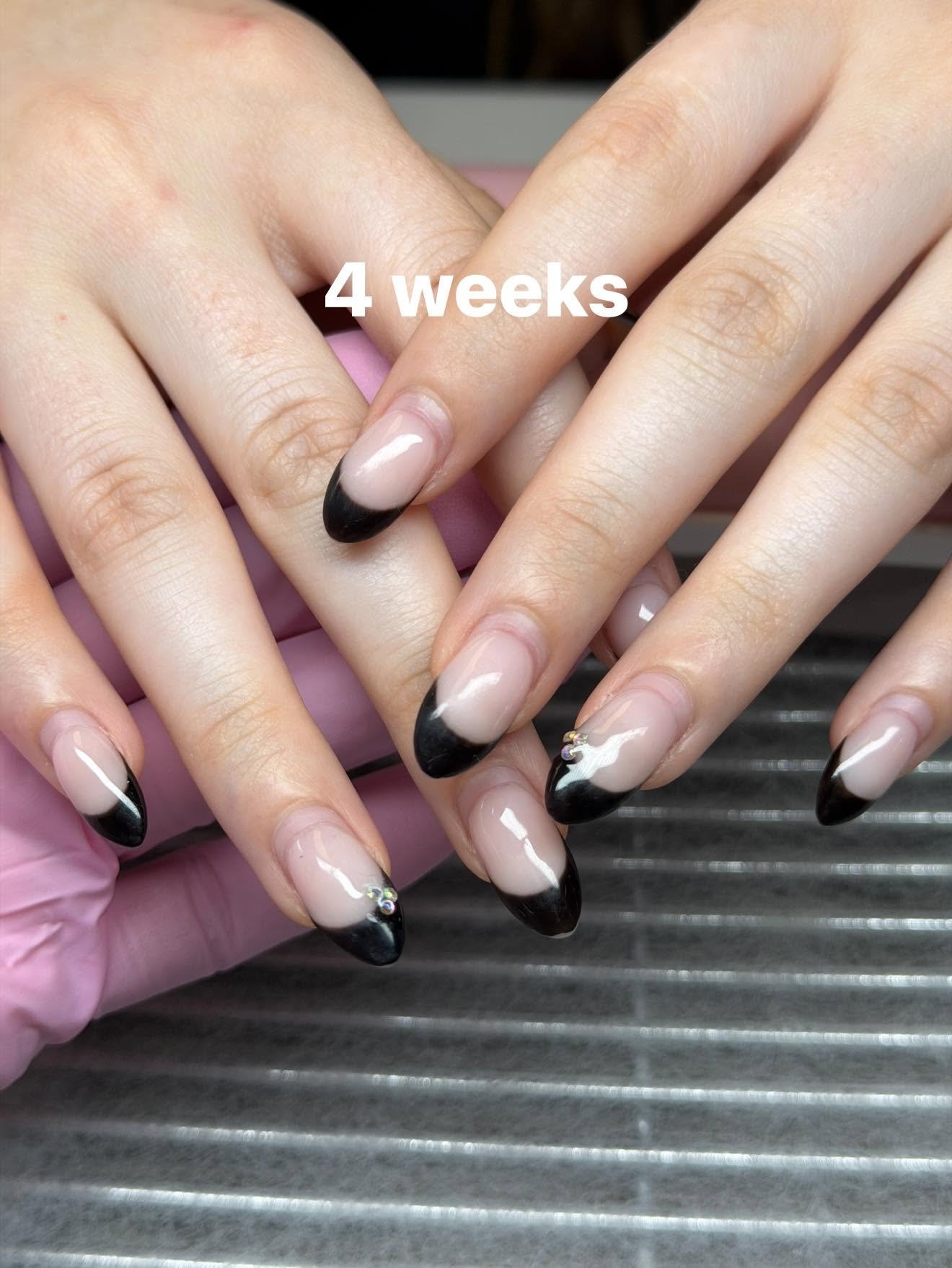 Black French tip nails with a rhinestone accent