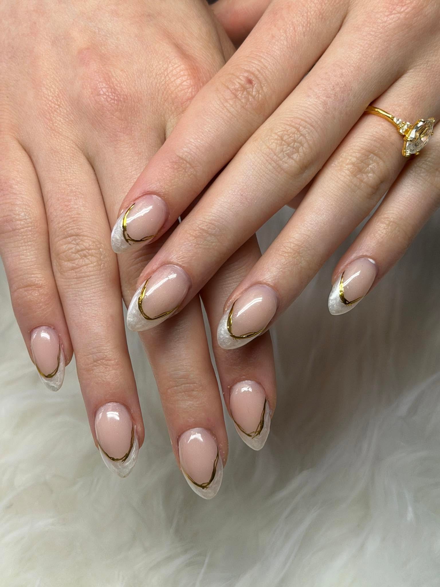 Nude nails with white marbled French tips lined in gold