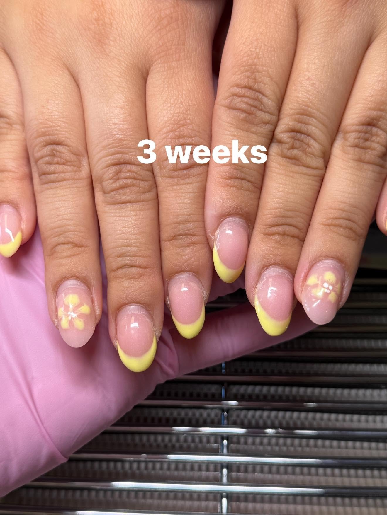 Yellow French tips with a small flower accent