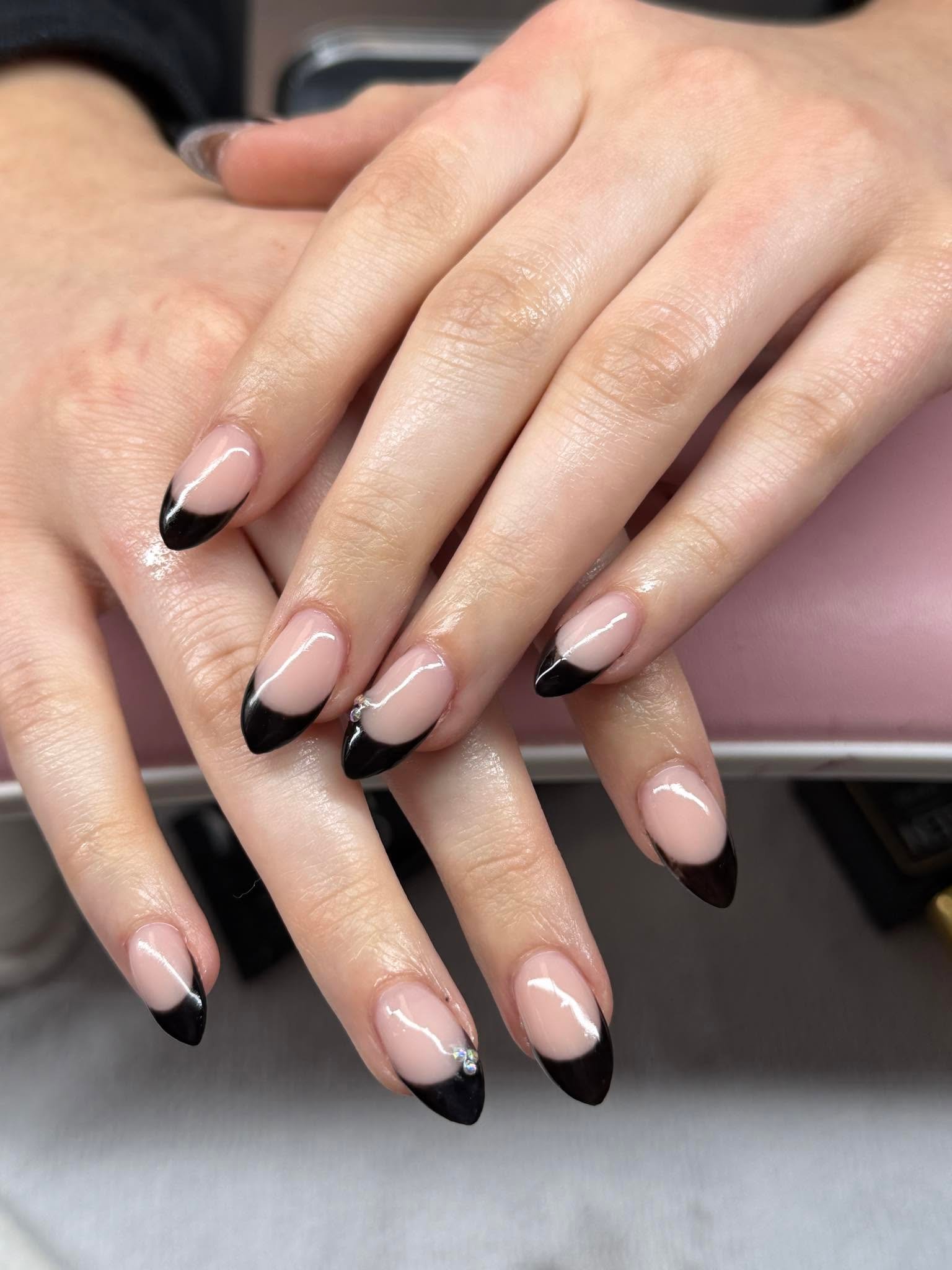 Almond nude nails with sleek black French tips