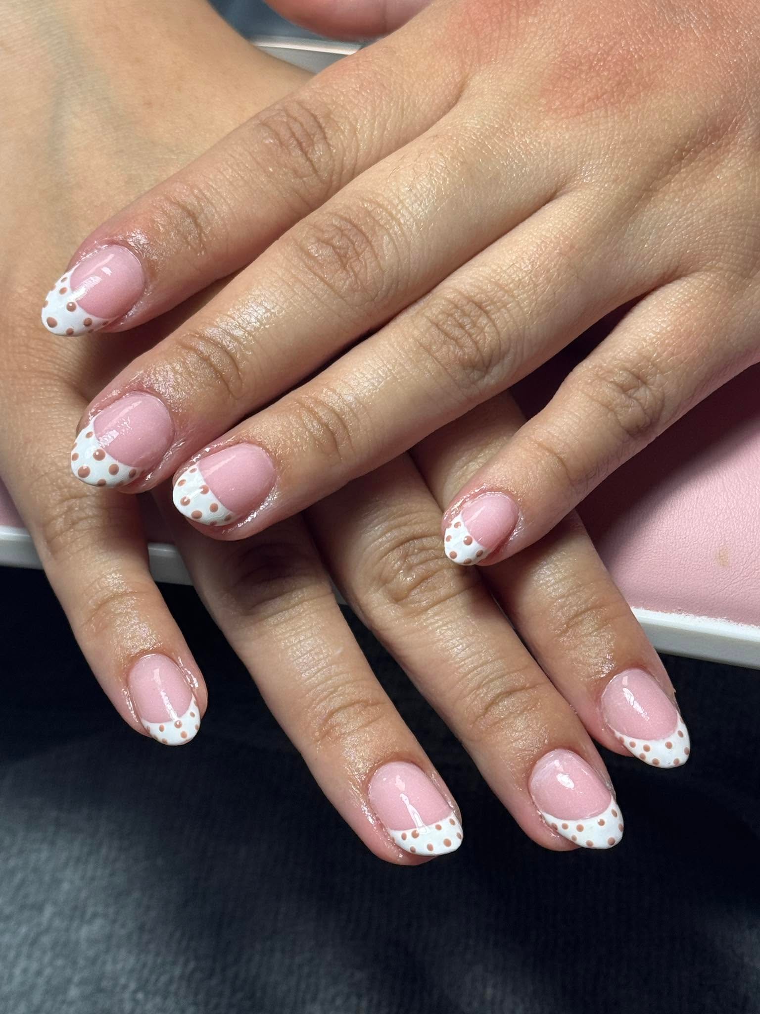 Pink French manicure with brown polka dot pattern on white tips
