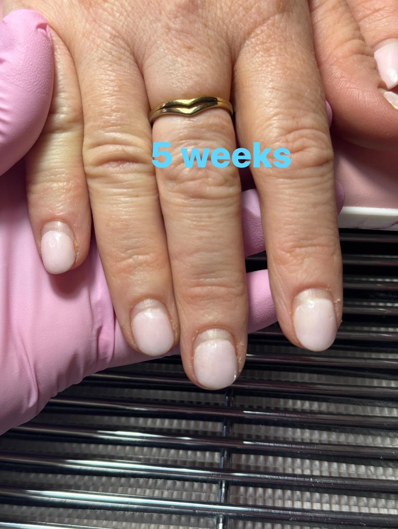Sheer pale pink gel manicure with a gold ring