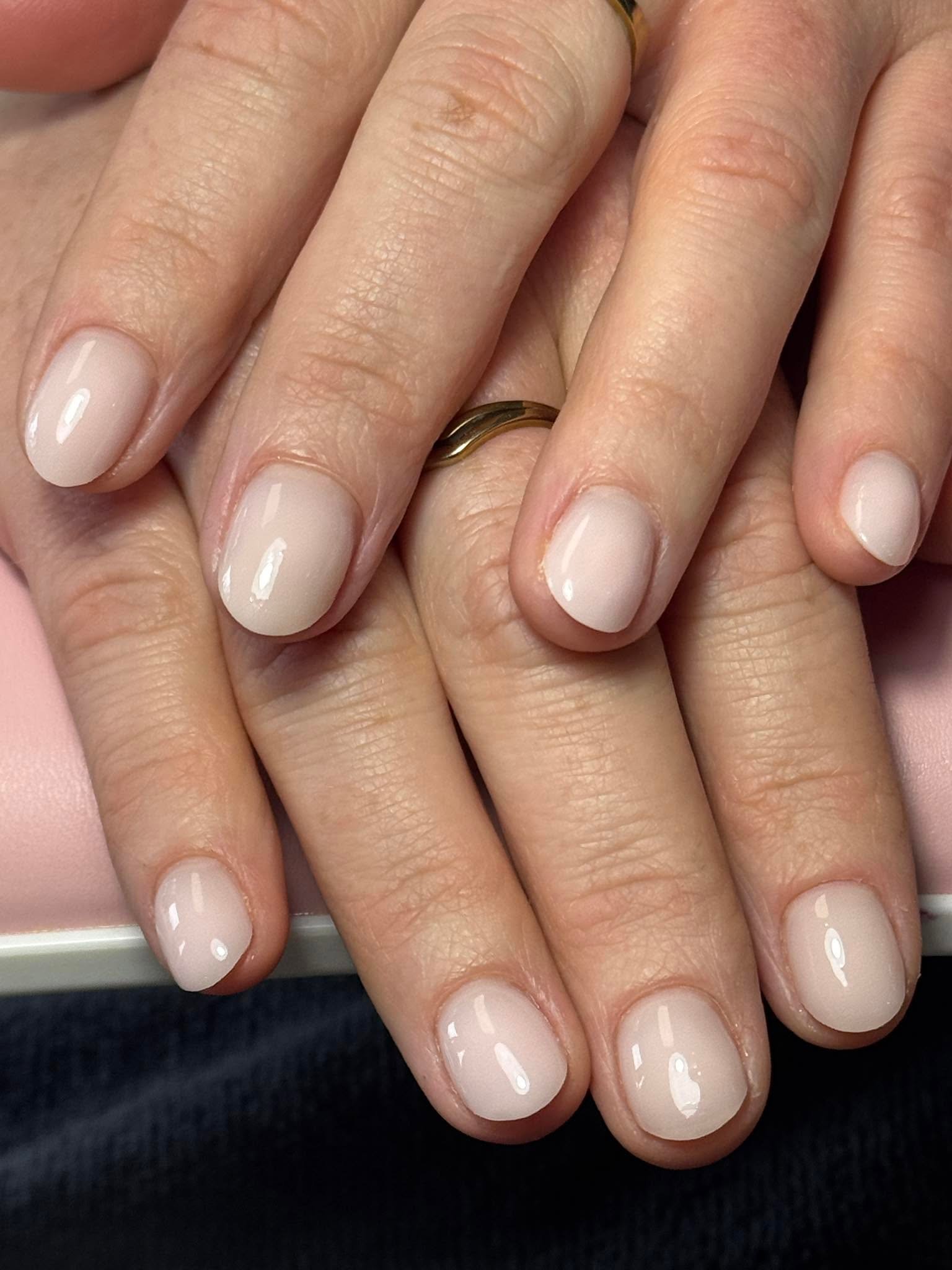 Natural nude glossy gel manicure with a gold ring