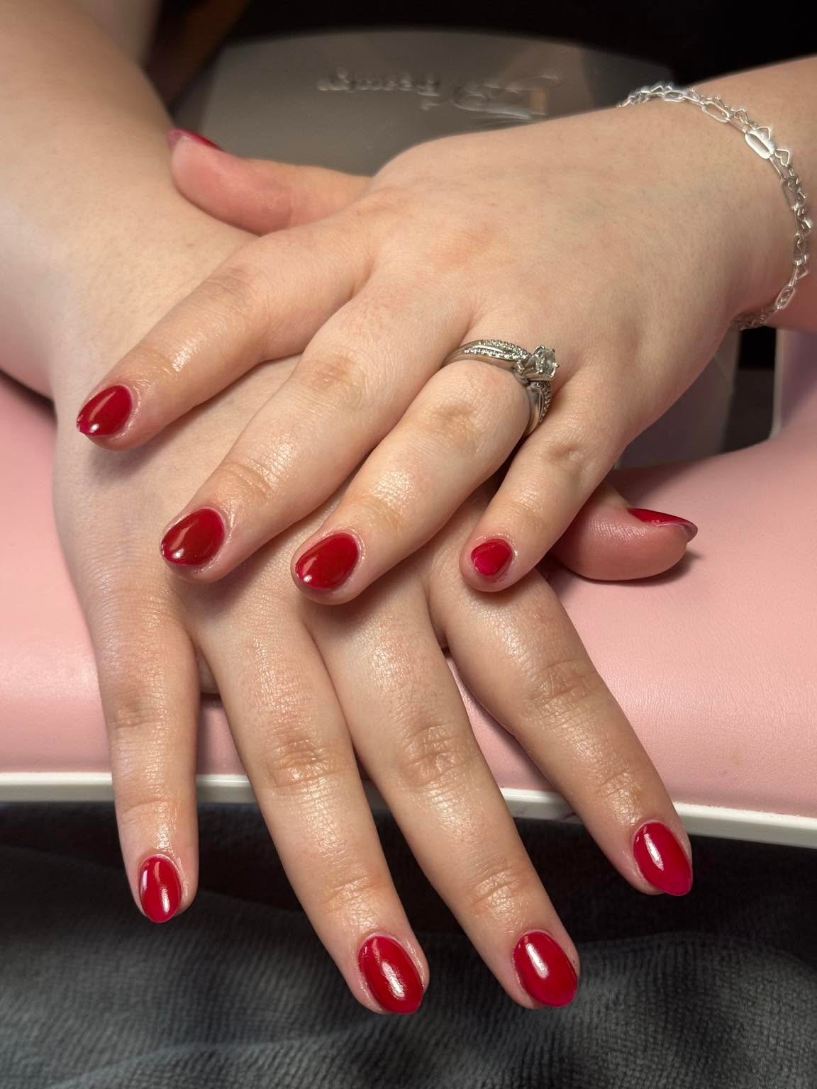 Classic red gel manicure with a diamond ring