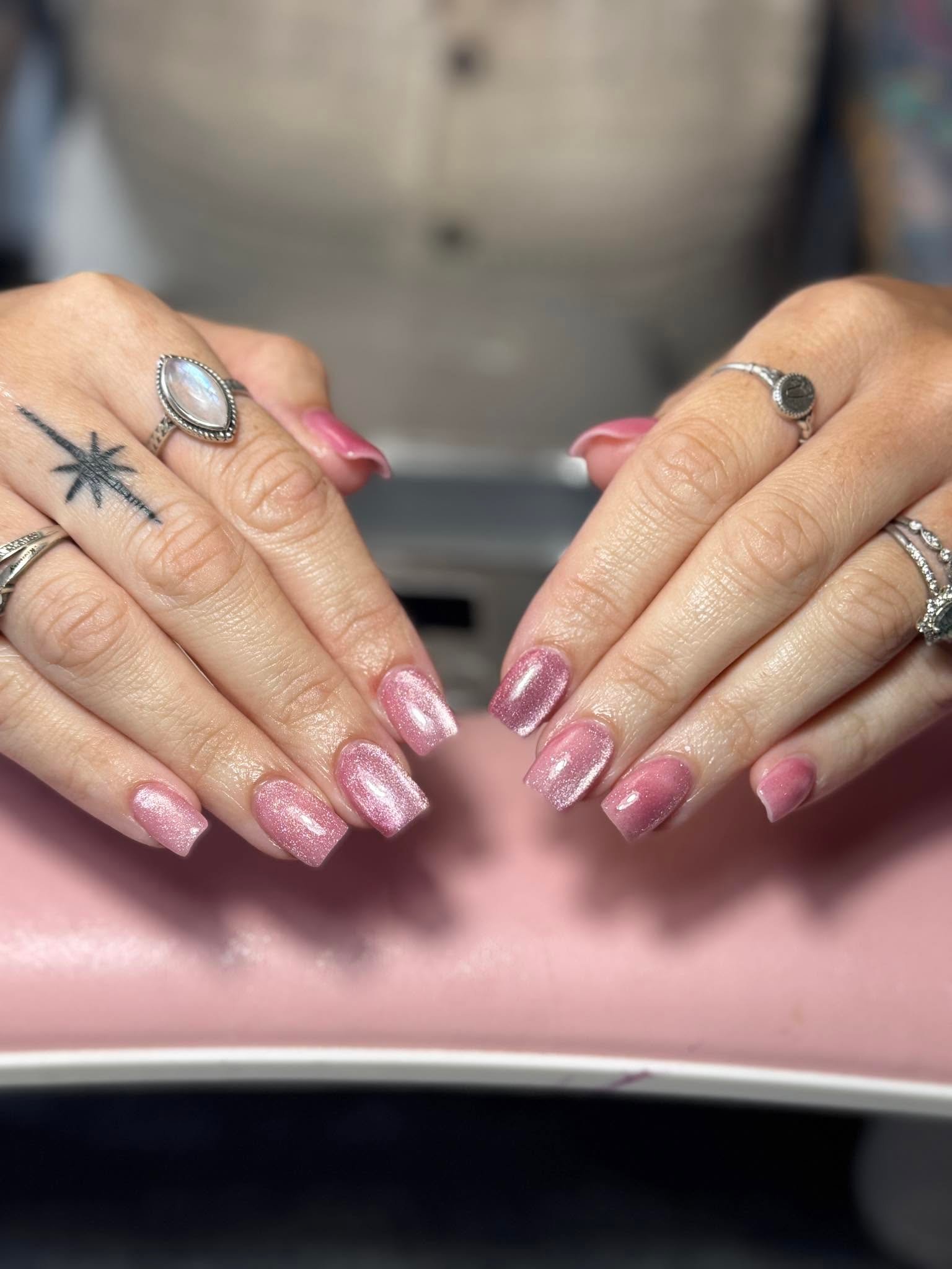 Shimmery pink gel manicure with layered rings
