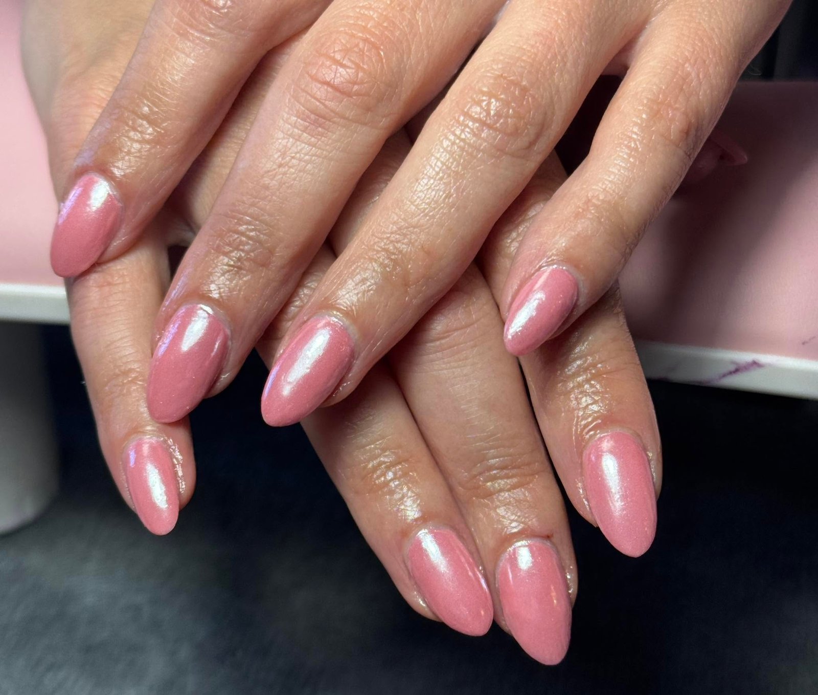 Shimmering pink solid gel manicure on almond nails