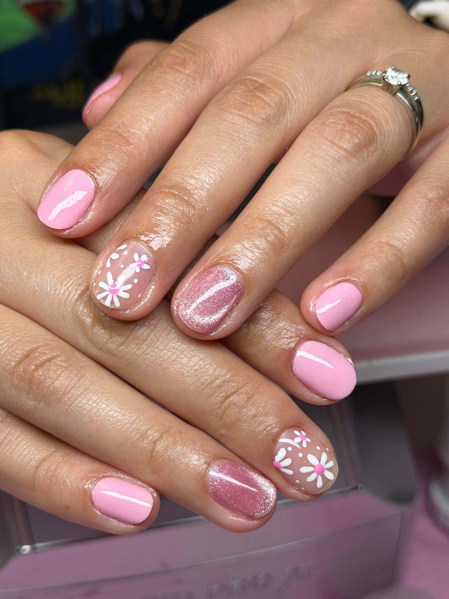 Pink glitter nails with hand-painted daisy accents
