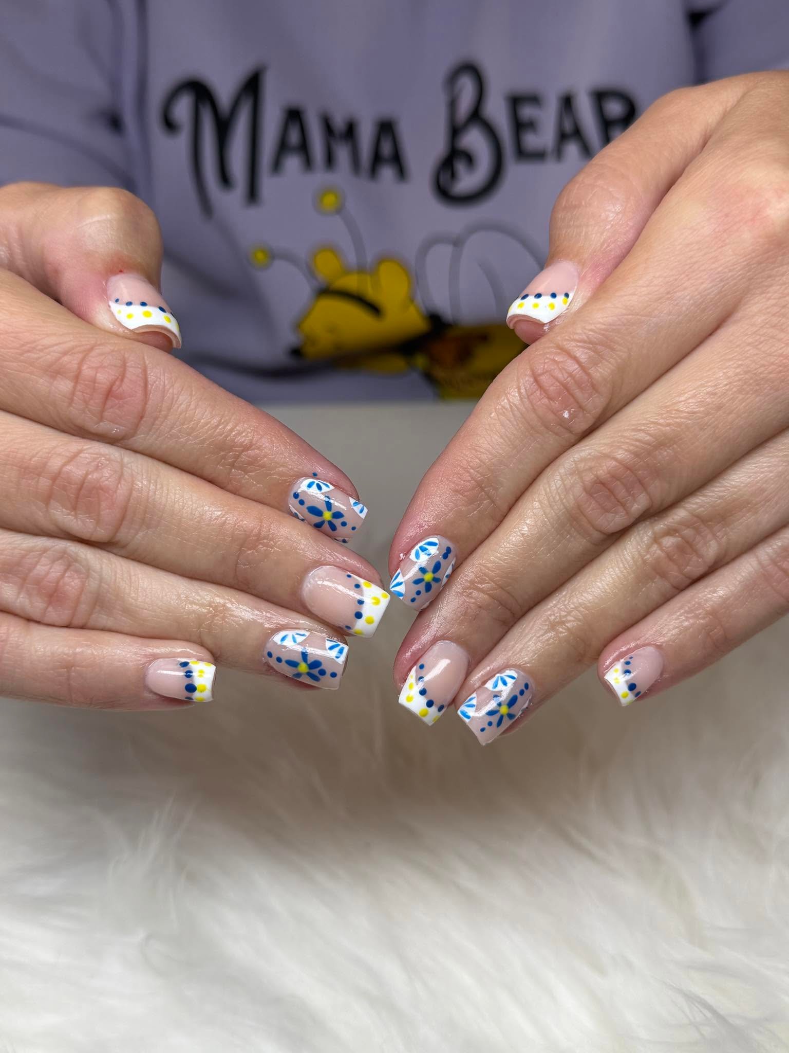 French tips with hand-painted blue and yellow flower doodles