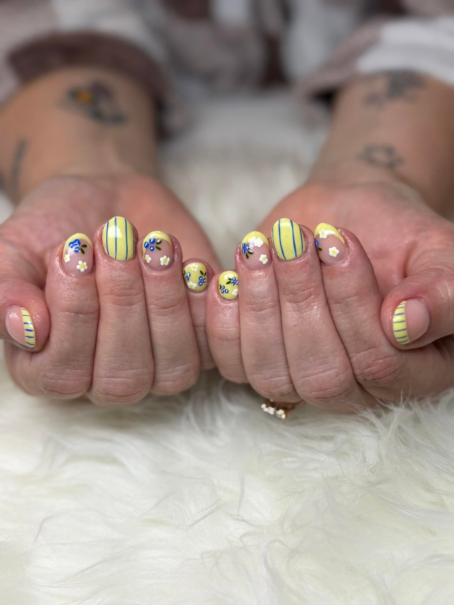 Pastel yellow nails with delicate hand-painted flower accents