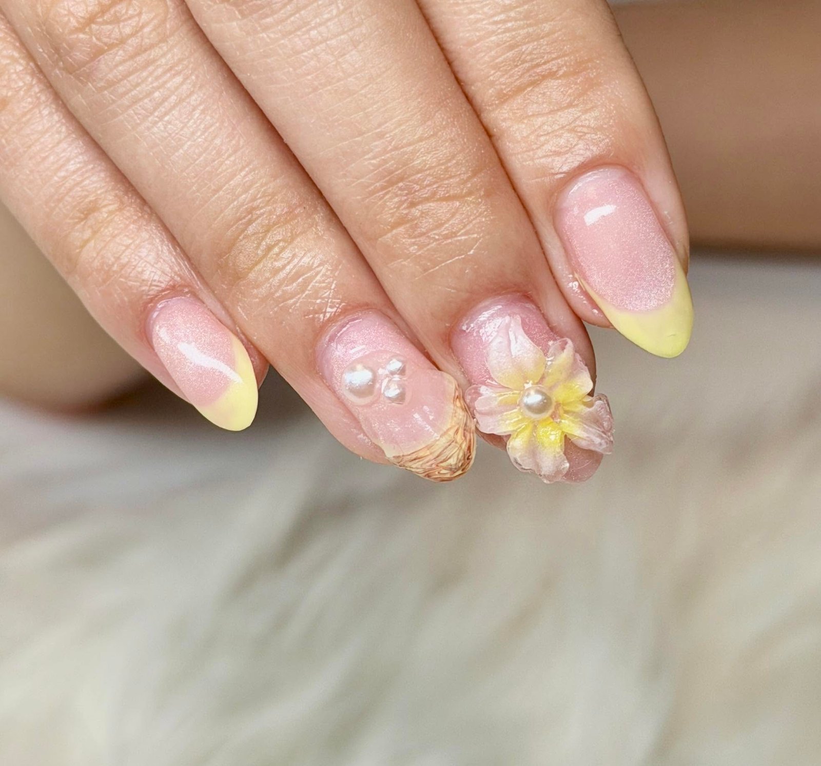 Iridescent pastel nails with a 3D flower and pearl accents