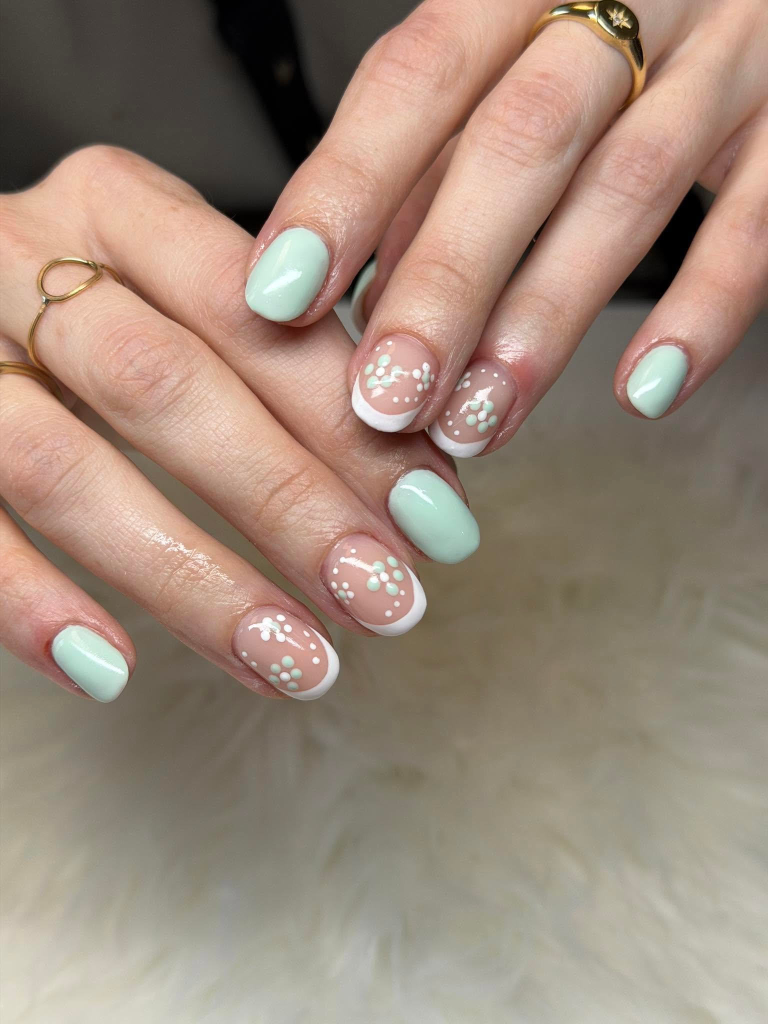 Mint green nails paired with floral dotted French tips
