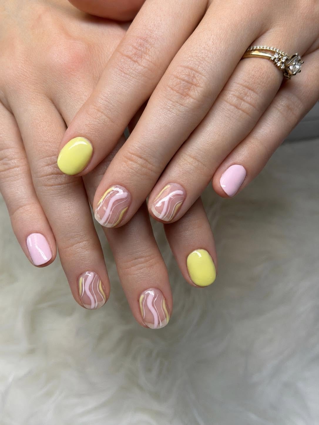 Yellow and pink nails with wavy marbled line accents