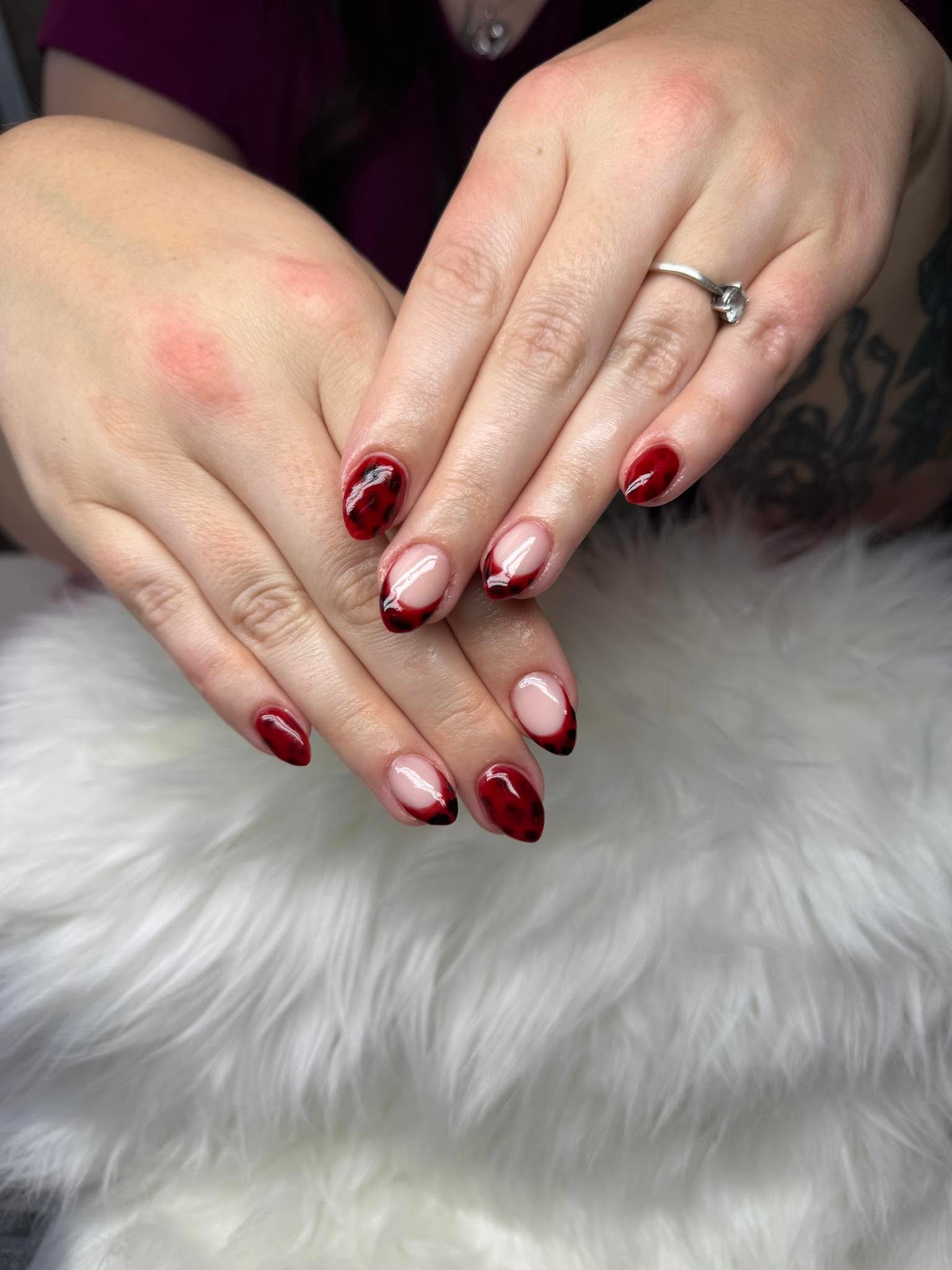 Nude nails with red leopard print French tips