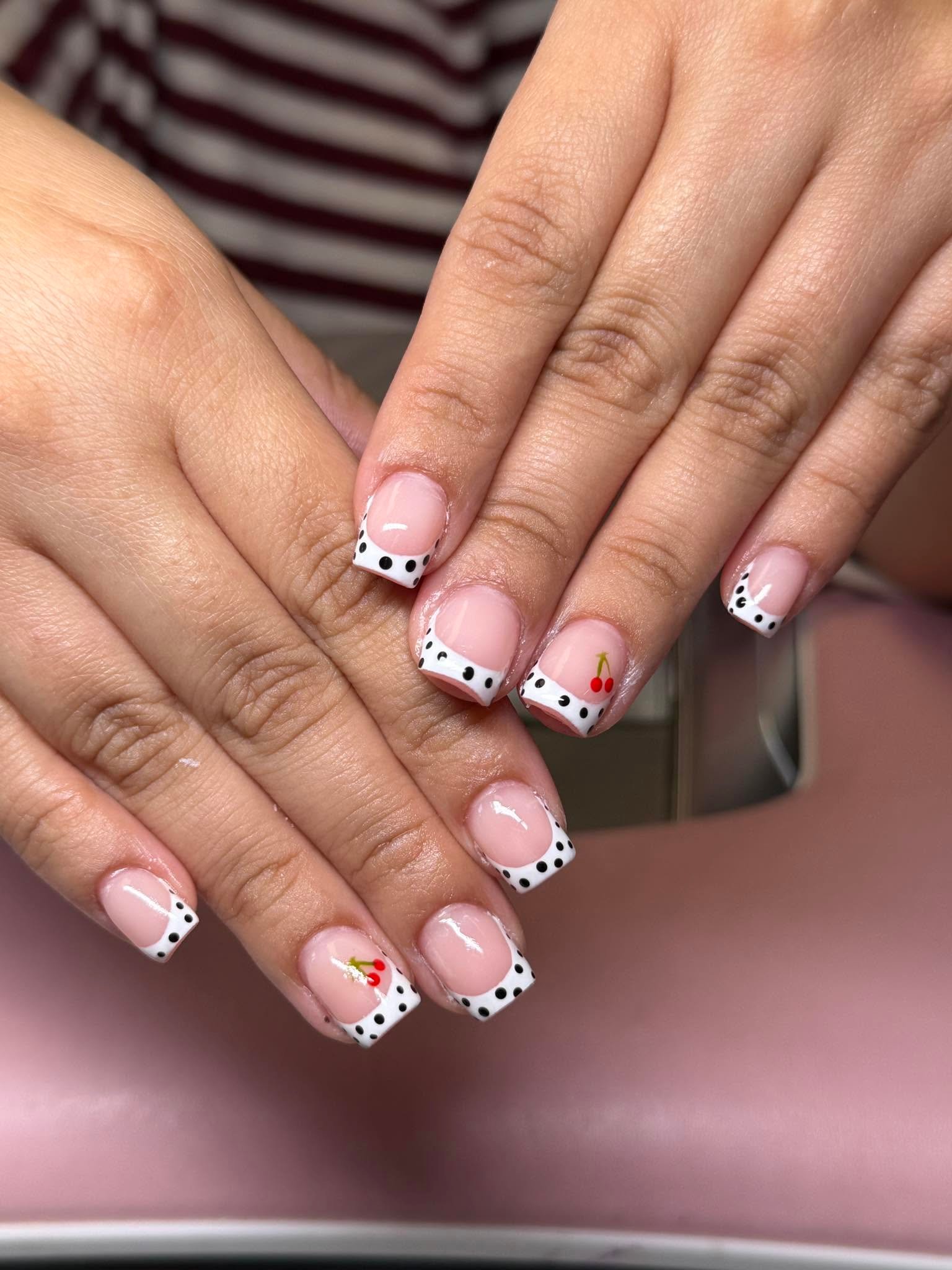 Polka dot French tips with a playful cherry accent