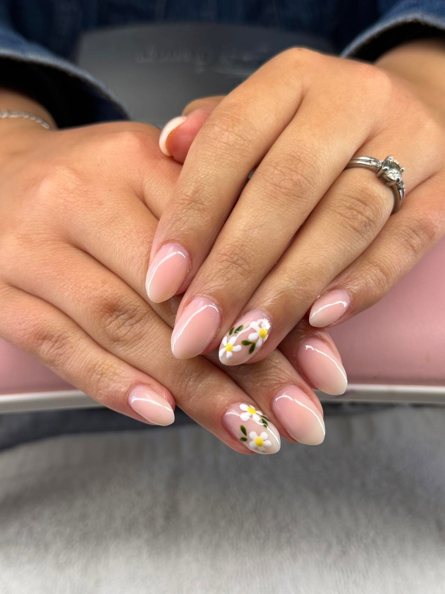 Nude nails with a single hand-painted daisy accent