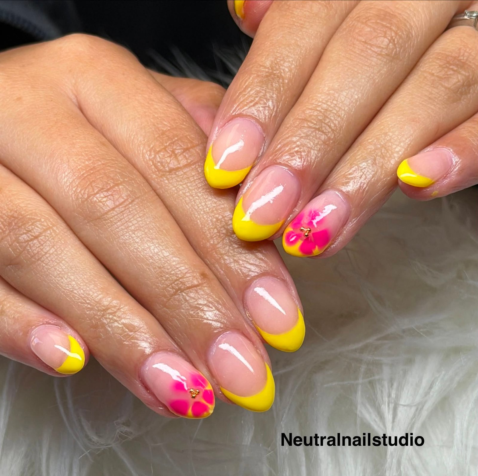 Yellow French tips with hand-painted pink flower and gold gem