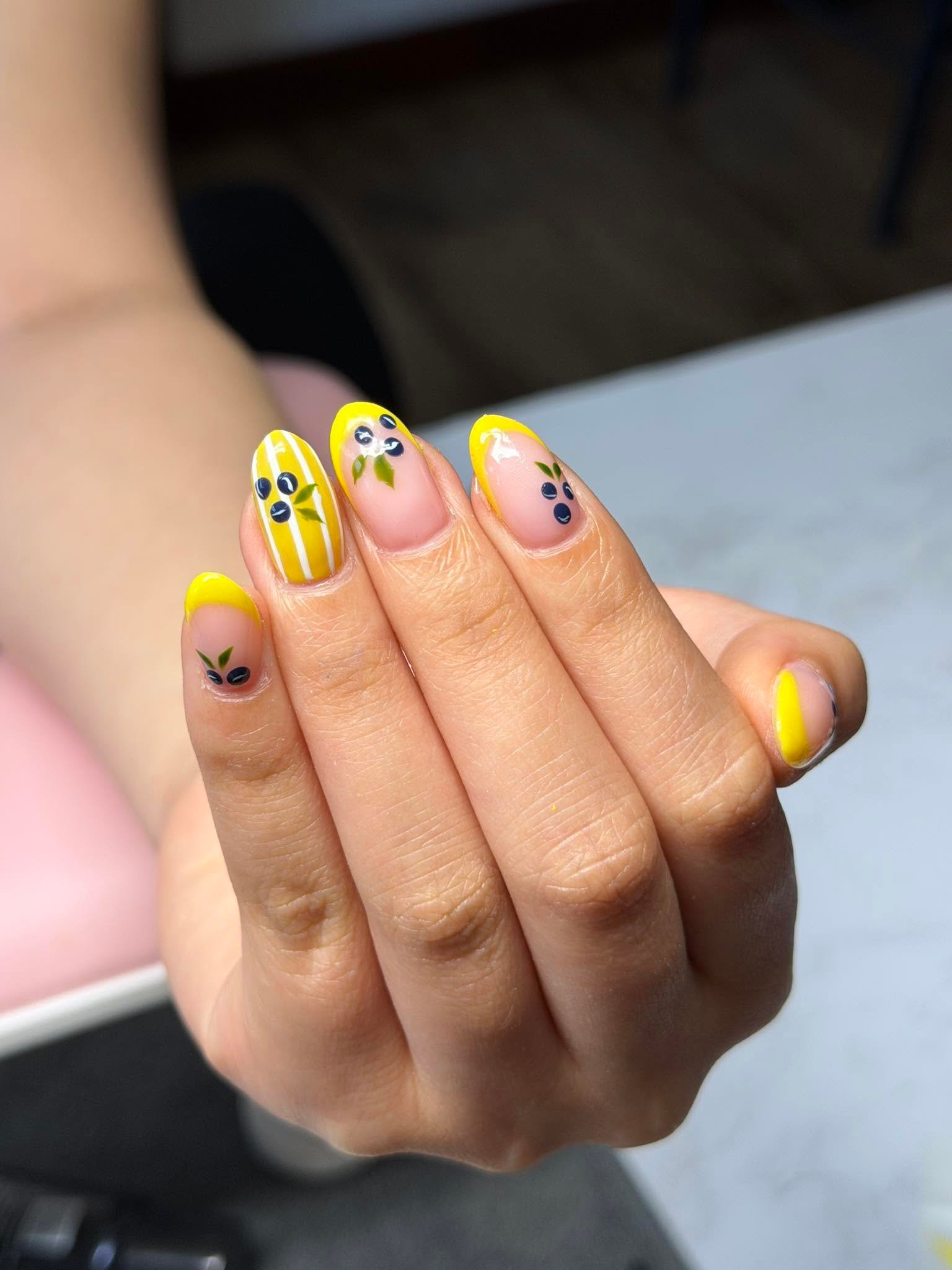 Yellow nails with navy leaf and dot accents plus stripes