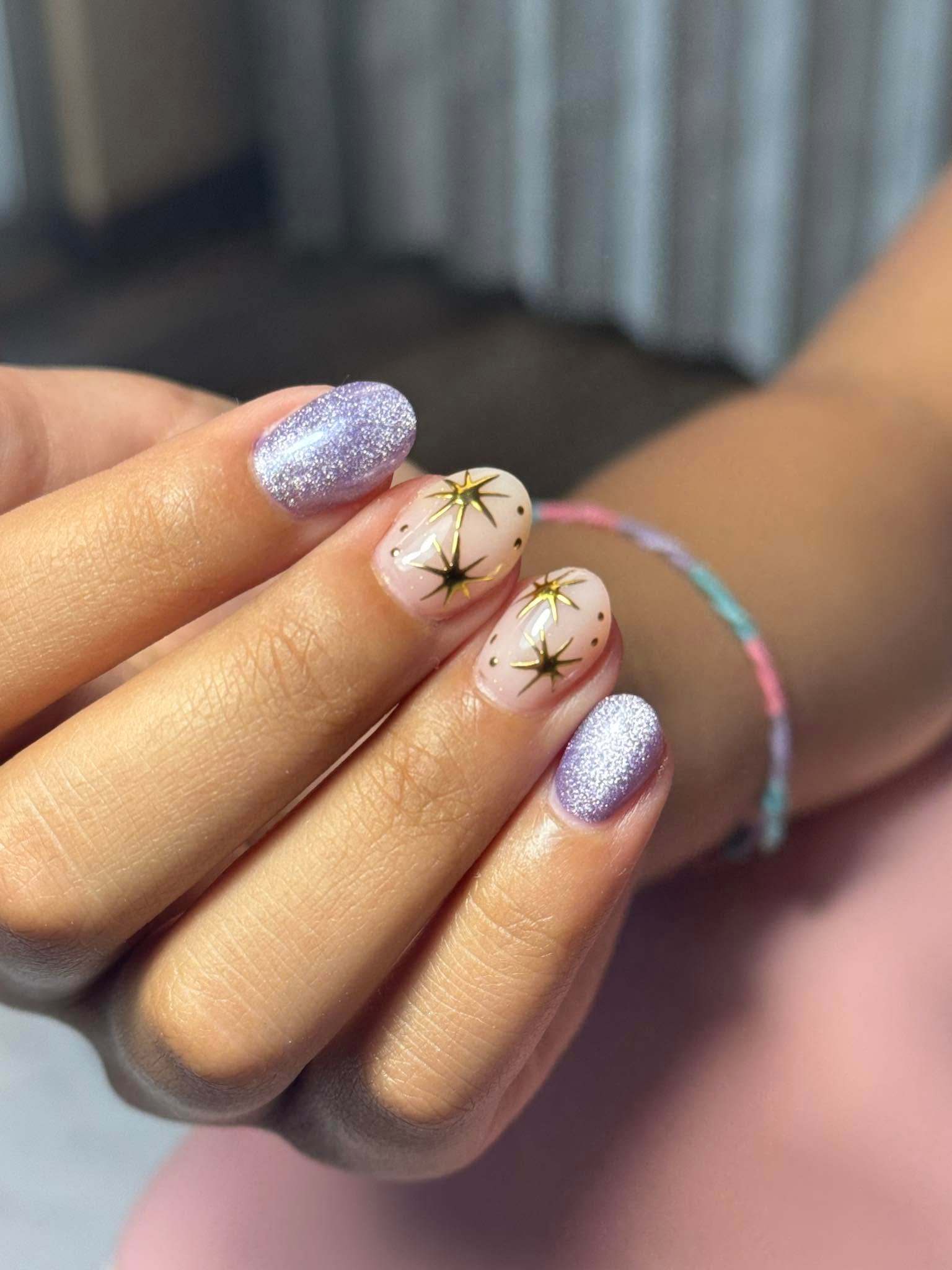 Lilac glitter nails with gold star burst art accents