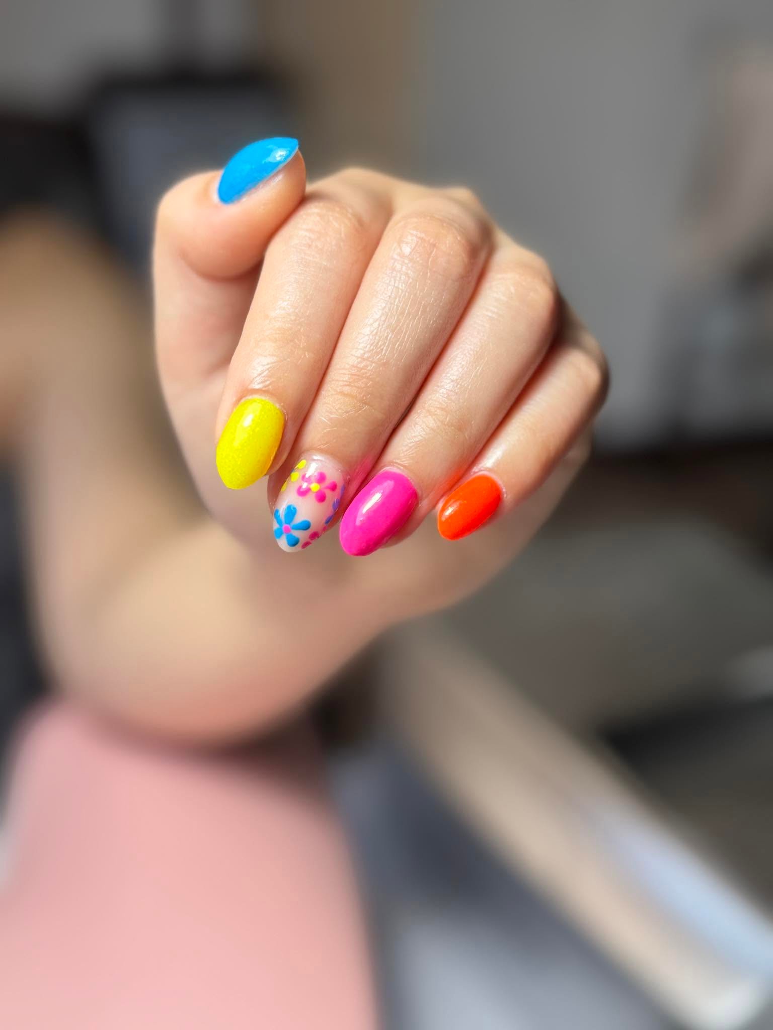 Bright rainbow manicure with yellow, pink, orange and hand-painted floral accent
