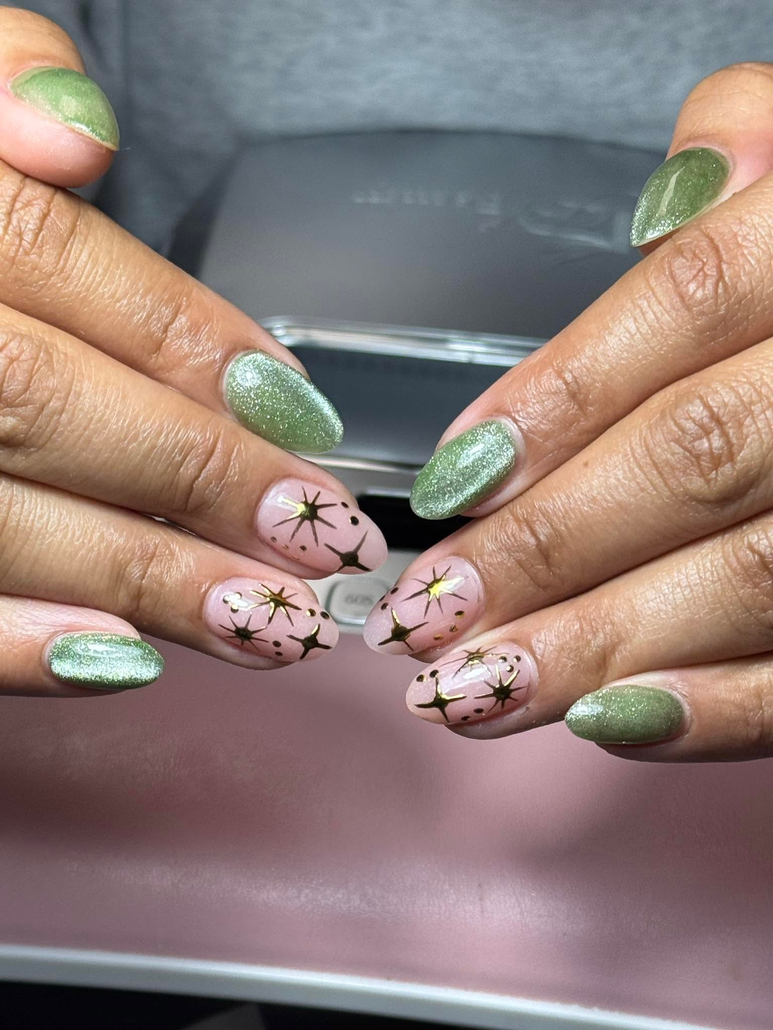Sage green shimmer nails with gold star nail art accents