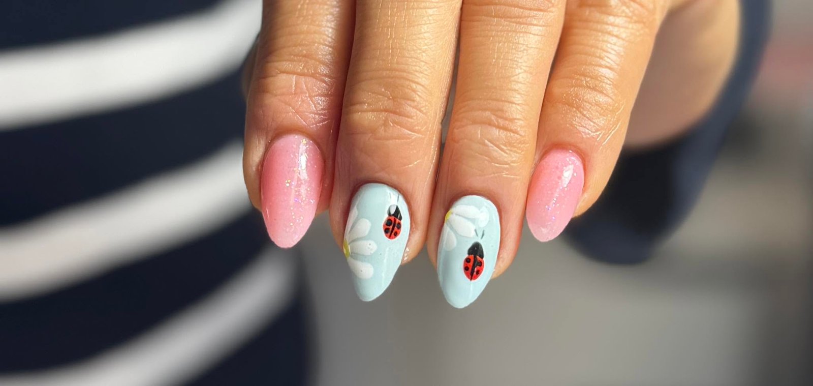Pink glitter and mint nails with white daisy and ladybug nail art