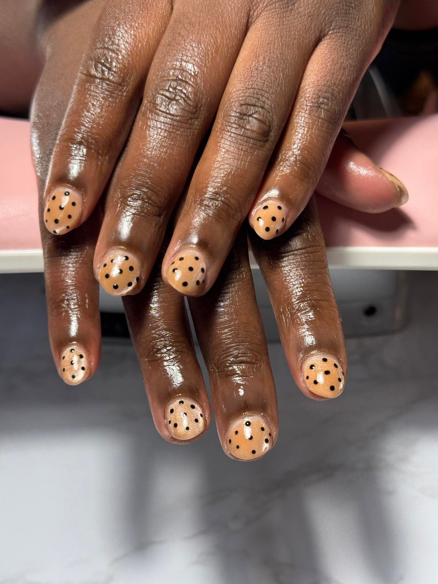 Warm tan nails with black polka dot nail art