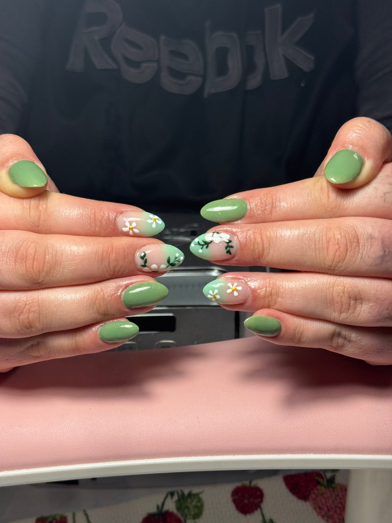 Sage green manicure with hand-painted white daisy nail art