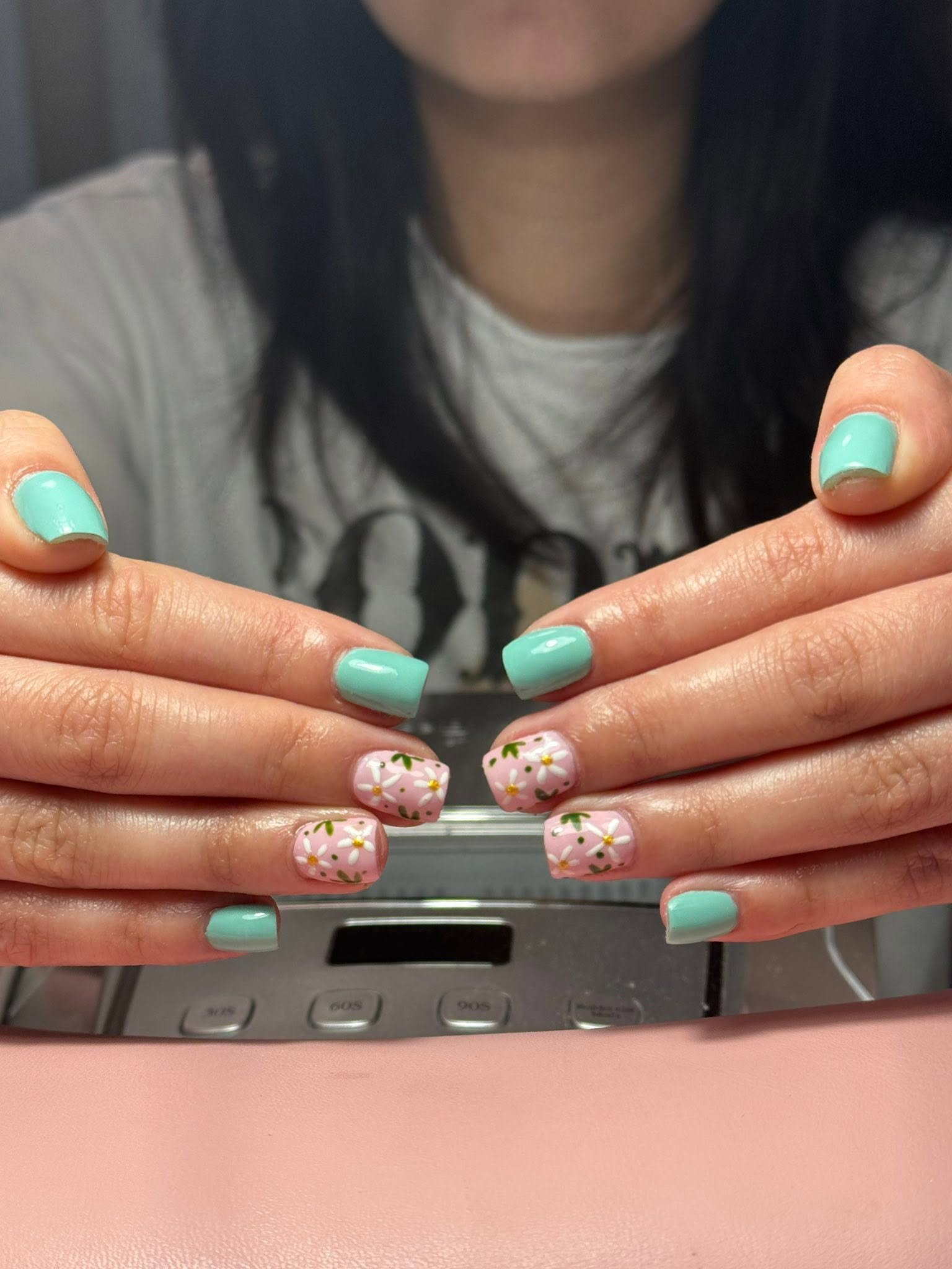 Mint green nails with hand-painted pink daisy accents