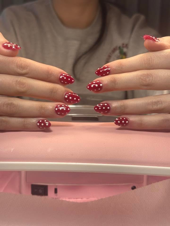 Red nails with hand-painted white polka dots