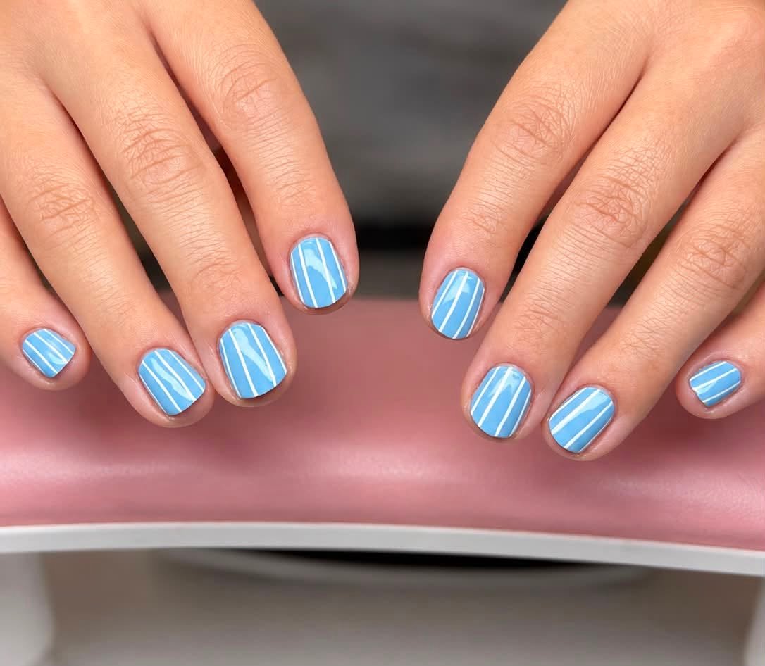 Sky blue manicure with white pinstripe accents