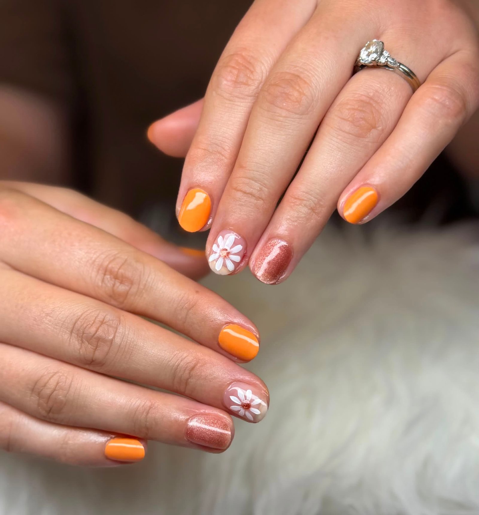Orange manicure with white daisy accent nails