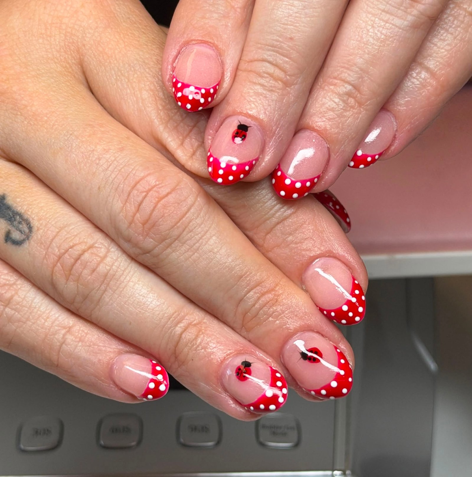 Red manicure with polka dots and ladybug art