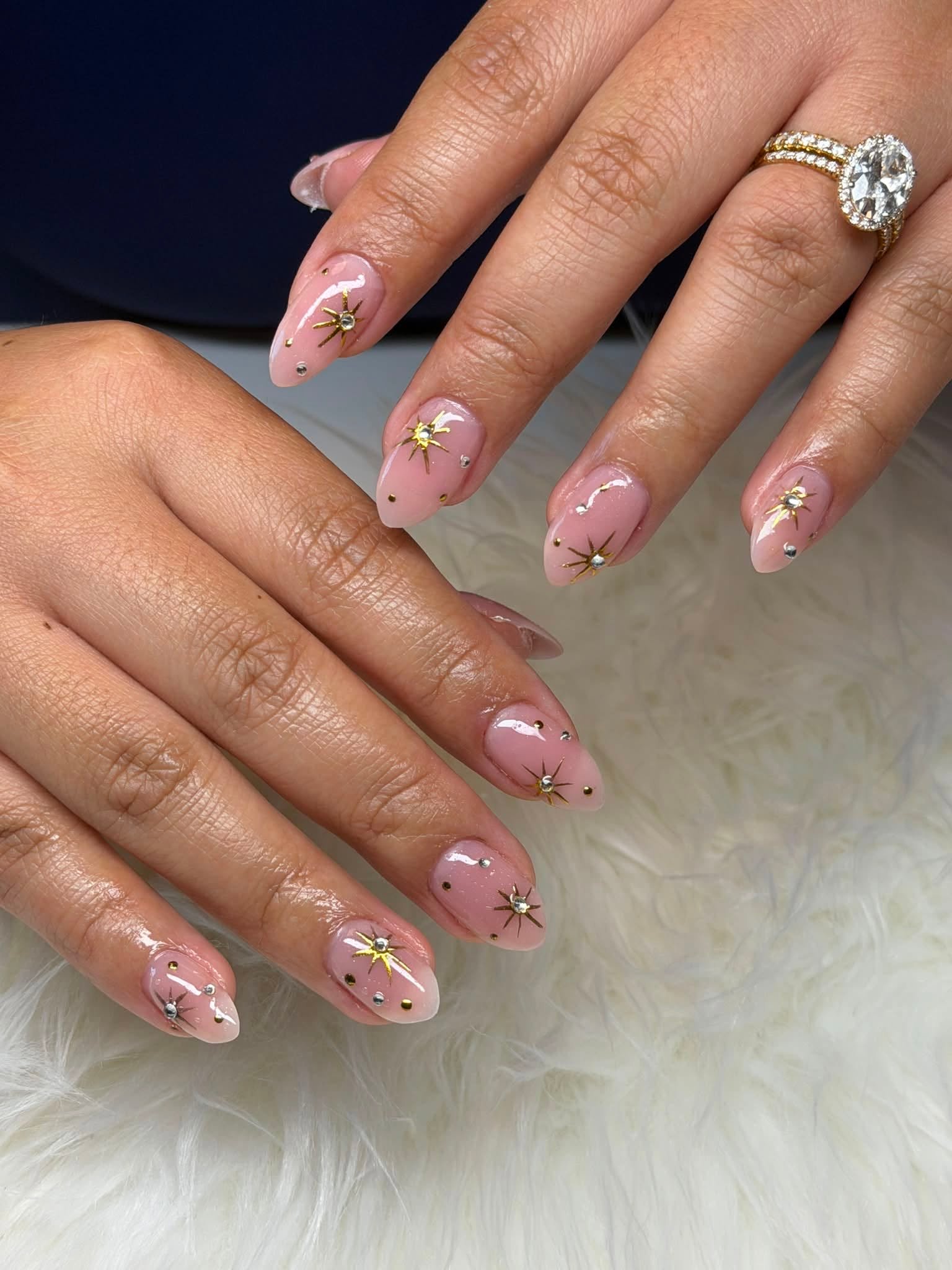 Nude manicure with gold star and rhinestone design
