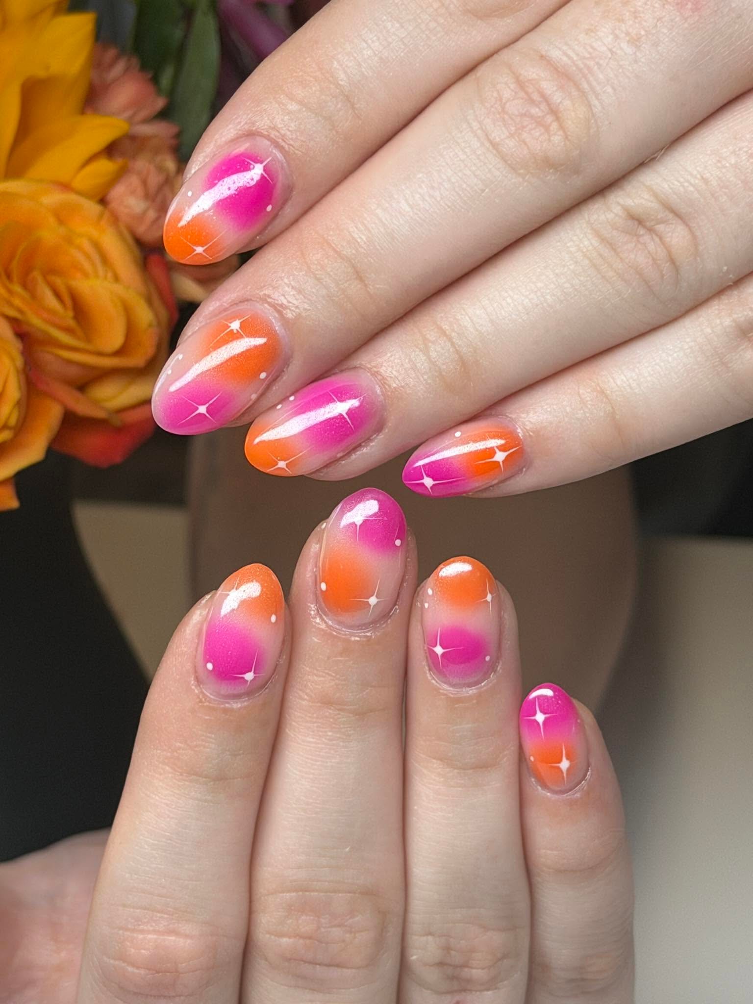 Pink and orange ombre nails with star accents